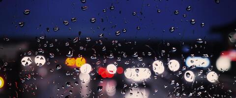 Driving in raining. Rain on car windshield or car window in rainy season and blurry traffic road in background. Rain drops on car mirror. Road in rain. Drizzle raining decreases driving visibility. photo