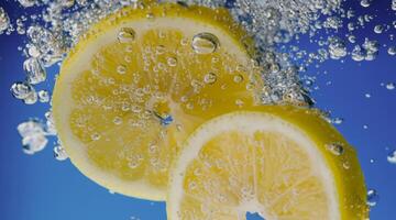 Underwater lemon slice in soda water or lemonade with bubbles. photo