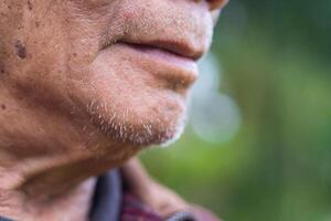 Close-up of a half-face senior man with a nature background. Concept of aged people and healthcare photo