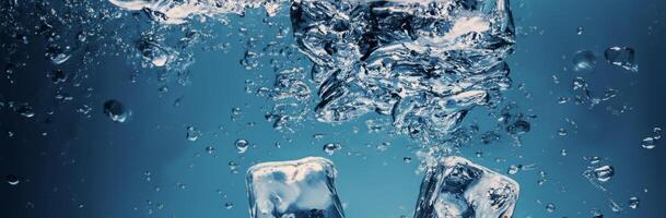 Water splashing and ice cube. Ice splashing into a glass of water. Underwater pouring ice cubes falling into clear watering background. Refreshing chill drinking. Ices in a glass with blue background photo