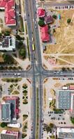 vertical accelerated video aerial view above at crossroads on road junction with heavy traffic in city
