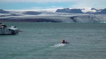 une bateau flottant par une fusion glacier lagune à jökulsarlon, Islande. 4k video