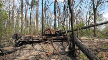 Destroyed and burnt-out tank of the Russian army as a result of the battle with Ukrainian troops in the forest near Kyiv, Ukraine. Russian aggression in Ukraine. video