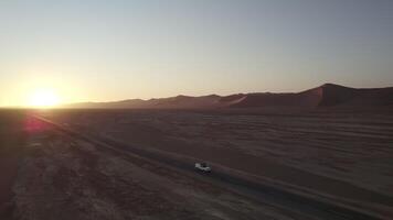 carro dirigindo em sossusvlei estrada dentro Namíbia em uma pôr do sol video
