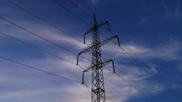 Time lapse of high voltage power line and electricity pylons. Beautiful clouds move in the sky. 4K video