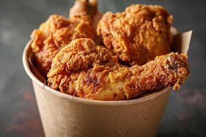 AI generated Golden brown and crispy roasted fried chicken served in a brown paper bucket photo