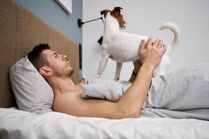 Man sleeping on bed with dog. Pet affection photo