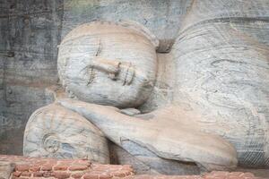 hermosa cara de reclinable Buda es 14 metro largo, imaginando Buda entrando nirvana a galón vihara en antiguo ciudad de polonnaruwa, sri lanka. foto