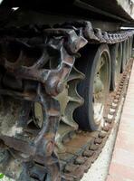 Rusty tracks of a crawler military armored carrier vehicle closeup photo for a vertical story