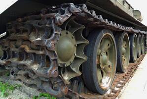 Tracks and rollers of a tracked tank packed with sand with traces of rust photo