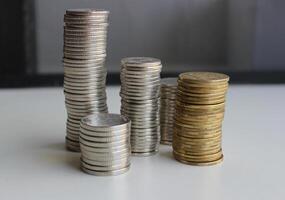 Piles of coins of different denominations from different alloys on a white table isolated stock photo