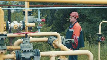 Ingenieur beim das Gas Verteilung Komplex macht ein Umleitung beim das Gas Bahnhof. ein Mitarbeiter von ein Gas Produktion Unternehmen funktioniert beim ein Gas Produktion Bahnhof video