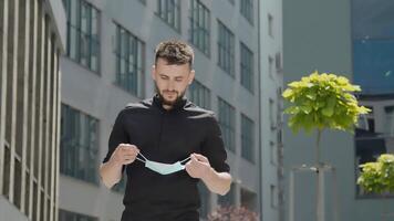 Portrait of a Man wearing a medical protective mask and breathing air on the streets of the metropolis through a mask. video