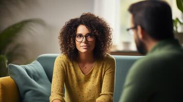 AI generated Serious woman in eyeglasses sitting on sofa and talking with psychologist photo