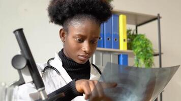 African american female doctor working with the x-ray at desk video