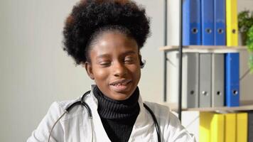 jung afrikanisch amerikanisch Frau Arzt haben Plaudern oder Beratung auf Laptop suchen direkt zu das Kamera video