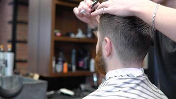 Short haircut in a barbershop. Close-up. Caucasian young client and barber in barbershop video