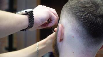 a processo do corte uma vermelho barba com uma perigoso navalha dentro uma barbearia video