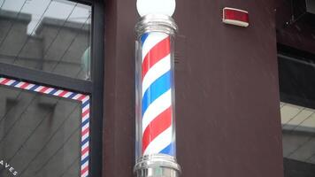 Barber pole with broun wall on background. Outside winter view video