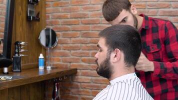 Jeune élégant coiffeur coupes une du client cheveux dans une salon de coiffure video