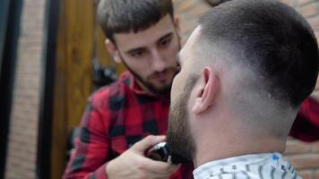 The hairdresser works on the client's style in a modern stylish barbershop video