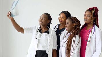 une groupe de quatre africain américain élèves discuter un radiographie video