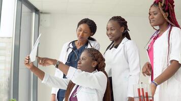 Young african doctors examine an X-ray while standing at a table video