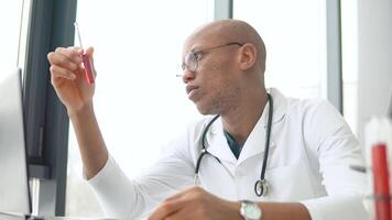 Young african american male doctor working with the blood in test tube in at desk. Development of the covid 19 vaccine video