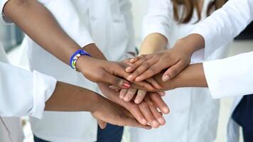 A team of doctors, including women and men of different nationalities, make a gesture of unity. Close-up shooting of hands video