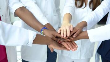 A team of doctors, including women and men of different nationalities, make a gesture of unity. Close-up shooting of hands video