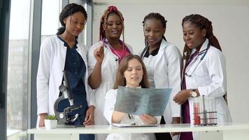 Young doctors examine an X-ray while standing at a table video