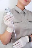 Professional Aesthetician Holding a Facial Machine Handpiece photo