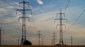 Time lapse of high voltage power line and electricity pylons. Beautiful clouds move in the sky. 4K video