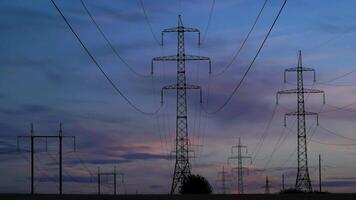 Time lapse of high voltage power line and electricity pylons. Beautiful clouds move in the sky. 4K video