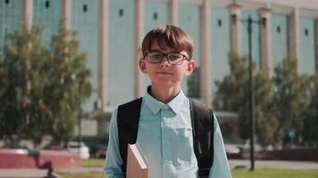 Online education, Back to school, Happy schoolboy, Learn lessons. Schoolboy with backpack goes to school holding textbook in hand video