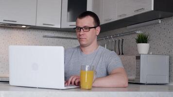 jung männlich Freiberufler beginnt ein Arbeiten Tag während Sitzung beim Zuhause beim ein Laptop. video