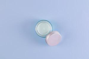 cosmetic jar with natural self-care cream on blue background. Top view. A copy space. Natural cosmetics. packaging. presentation. mockup photo