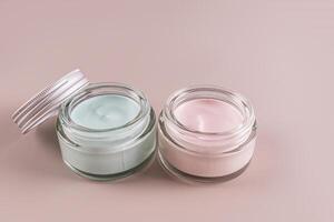 Two glass jars with face and body cream. Daily care. Natural cosmetics. layout. Delicate cream texture. Beige background. photo