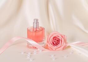 hermosa todavía vida con un botella de De las mujeres perfume o cosmético rociar en un beige satín antecedentes con rosado rosas y un satín cinta. disposición. foto