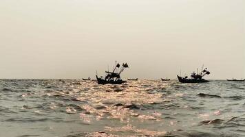 fishing boats during sunset sky at beach landscape, fishing boats during a sunrise or sunset, shimmering of the sun on the clouds,the sky and clouds have the power to inspire feelings of awe or wonder video