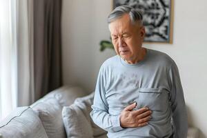 AI generated Asian senior man suffering from abdominal pain. photo