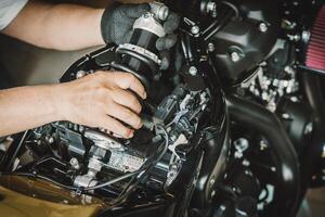 motocicleta mecánico reemplazar posterior conmoción absorbentes en motocicleta a cochera, reparar, mantenimiento y Servicio concepto foto