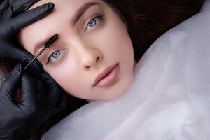 A girl poses in front of the camera after a permanent makeup procedure. PMU Procedure, Permanent Eyebrow Makeup. photo