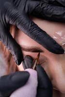 A tattoo machine with a permanent makeup cartridge introduces pigment into the skin of the eyebrows. PMU Procedure, Permanent Eyebrow Makeup. photo