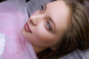 Girl model with blue eyes before permanent eyebrow makeup procedure. PMU Procedure, Permanent Eyebrow Makeup. photo
