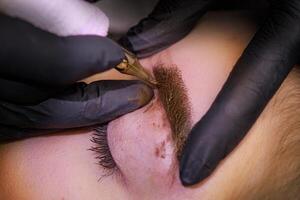 Macro photo of permanent eyebrow makeup application PMU Procedure, Permanent Eyebrow Makeup.