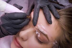 Master's work on permanent eyebrow makeup with a tattoo machine. PMU Procedure, Permanent Eyebrow Makeup. photo