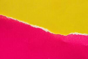 Ripped pink paper on yellow background. Torn paper background with copy space for text. photo