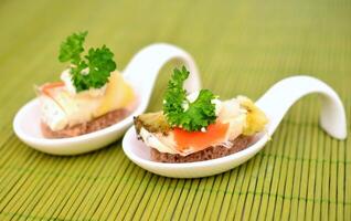 emparedados con salmón y crema queso en un blanco cuchara. foto