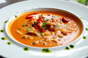 Mariscos sopa con Tomates y mejillones en un blanco plato foto